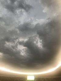 Low angle view of sunlight streaming through clouds