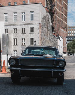 Car on street by buildings in city