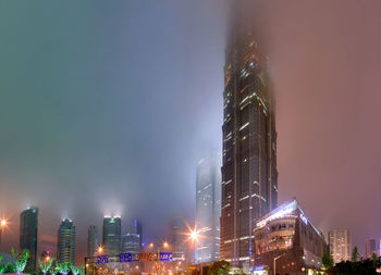 Low angle view of illuminated buildings against sky at night