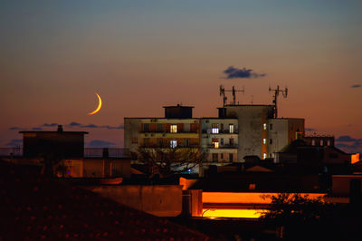 Illuminated cityscape against sky at night