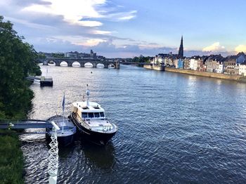 Boats in river with city in background