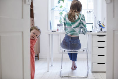 Rear view of women standing in corridor