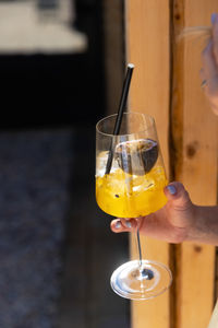 Girl drinking spritz aperol. woman holding glass with orange coctail