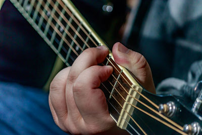 Midsection of man playing guitar