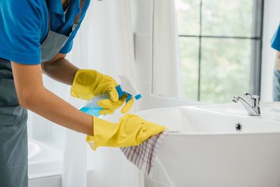 Midsection of man washing hands in bathroom