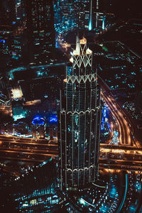 High angle view of illuminated street amidst buildings in city at night