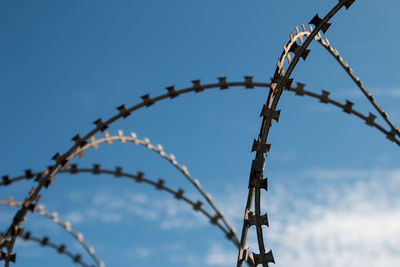 Low angle view of barbed wire against sky