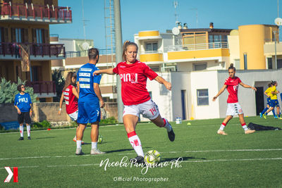 Group of people playing soccer on field