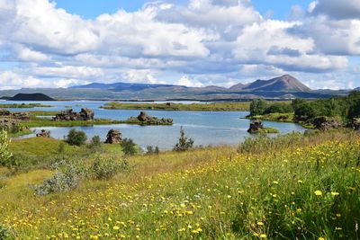 Scenic view of lake myvatn by mountains against cloudy sky