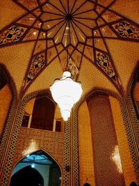 Low angle view of illuminated pendant light in building