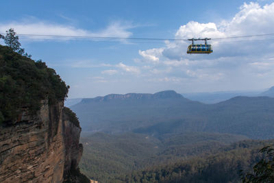 Scenic view of blue mountains against sky with cable car 