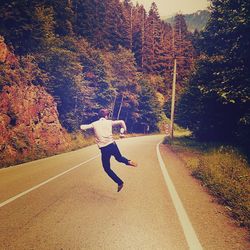 Rear view of woman walking on road