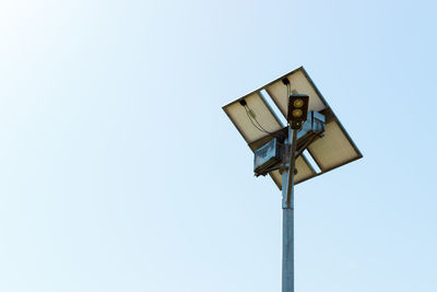 Low angle view of security camera against clear sky