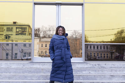 Portrait of smiling woman standing in snow