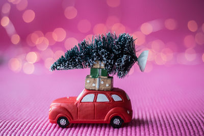 Close-up of christmas tree on toy car over table