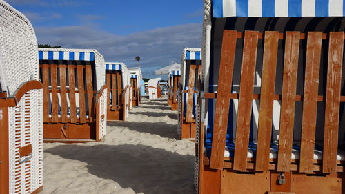 Seats on beach against blue sky