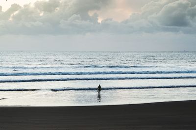 Silhouette person on beach against sky