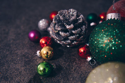 Close-up of pine amidst colorful baubles on table