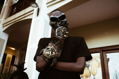 Low angle view of man wearing mask against building