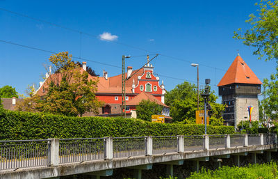 Canal by buildings against clear blue sky