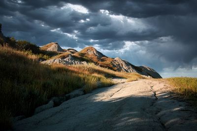 Scenic view of  tuscany clay hills under dramatic skies. a white pathway.   solitary place 