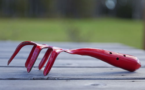 A red tool used in gardening with sharp tips