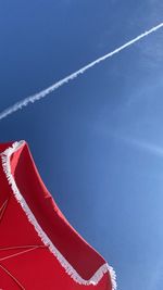 Low angle view of vapor trail against blue sky