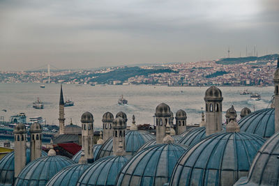 Cityscape by sea against sky