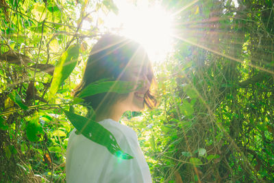 Woman standing on field against trees