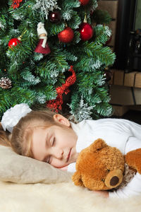 Full length of girl lying on christmas tree