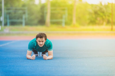 Portrait of young man exercising at stadium