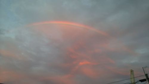 Low angle view of rainbow against cloudy sky