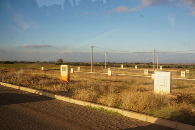 Road amidst field against sky