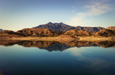 Scenic view of mountains by river against sky at potrerillos