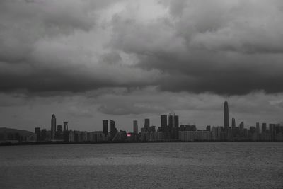 Sea by buildings against sky in city