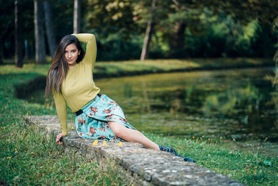 Portrait of beautiful young woman sitting at park