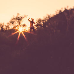 Low angle view of silhouette man against bright sun during sunset