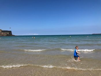 Boy on beach against sky