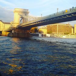 Golden gate bridge over river against sky in city