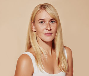 Portrait of young woman against pink background