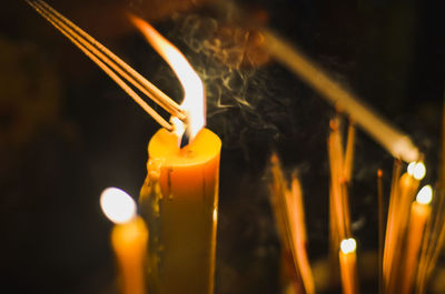 Close-up of lit candles in temple