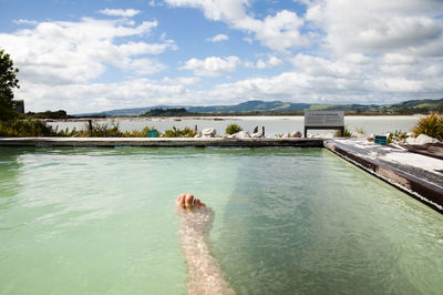 Swimming pool in sea against sky