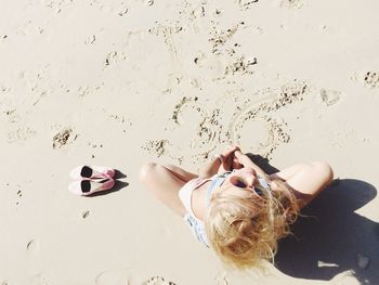 High angle view of woman sitting on sand at beach