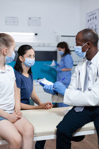 Portrait of doctor examining patient in office