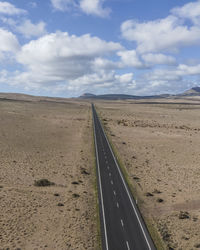 Aerial view of a road crossing a desert valley during a sunny day in teguise, lanzarote, canary 