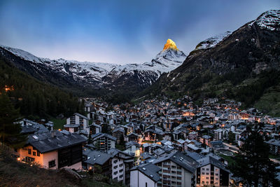 Aerial view of townscape against mountains during winter