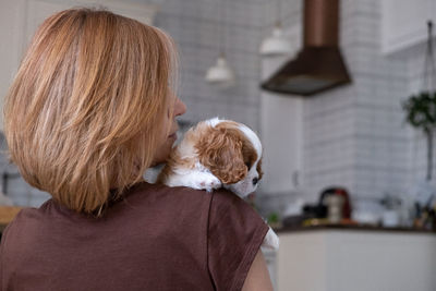 Cavalier king charles spaniel blenheim. close up portrait of cute dog puppy with woman hostess