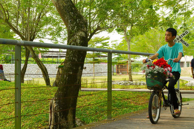 Portrait of young man riding bicycle on field