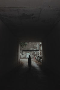 Rear view of man walking in tunnel