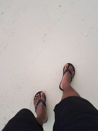 Low section of man standing on beach